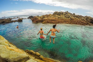 Girls jumping into the ocean in the Margaret River Region Snorkel or swim at Margaret River on the Cape to Cape tour.